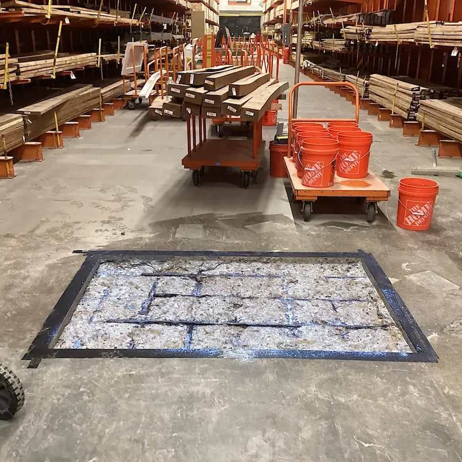 Steel reinforcement mesh installation in concrete floor cutout for structural repair.